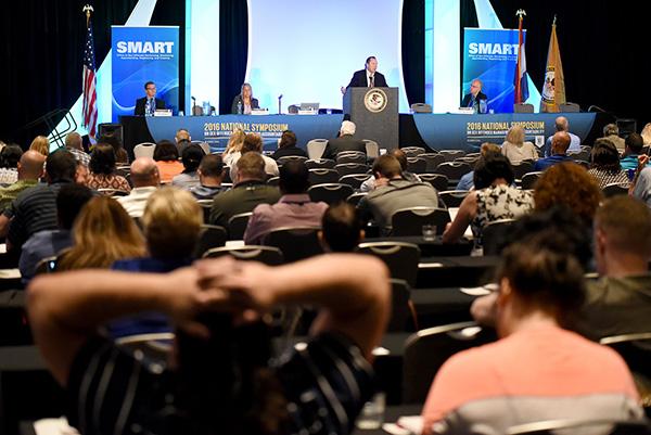 Roger Przybylski (center) speaks at the opening plenary presentation on SOMAPI, as Kevin Baldwin (from left), Dominique Simons and Chris Lobanov-Rostovsky listen.